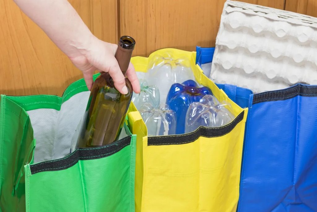 recycling center sorting empty wine bottle to green bag